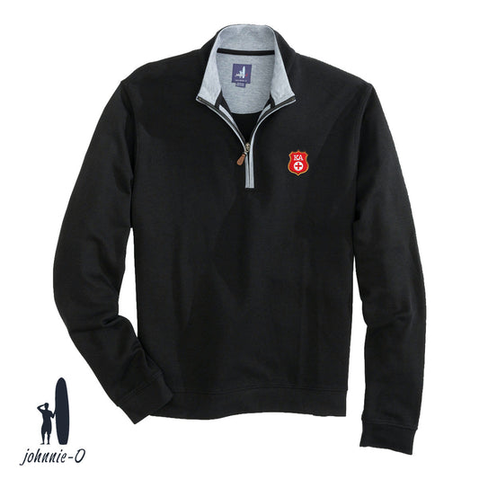 A black johnnie-O quarter-zip pullover with a gray collar and leather zipper pull, featuring an embroidered fraternity badge on the left chest. Displayed on a white background with the johnnie-O logo in the bottom corner.